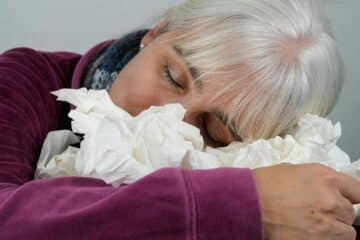 A woman with allergies and white hair covering her face