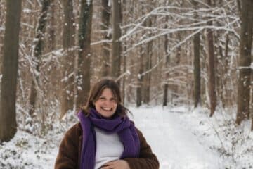 a pregnant woman is standing in the snow