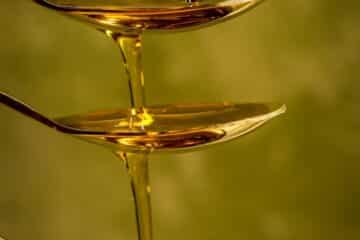 oil falling from one spoon to the next